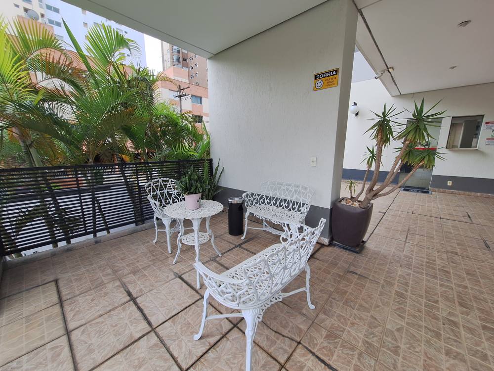 Área de convivência com mesa e bancos ao lado da portaria