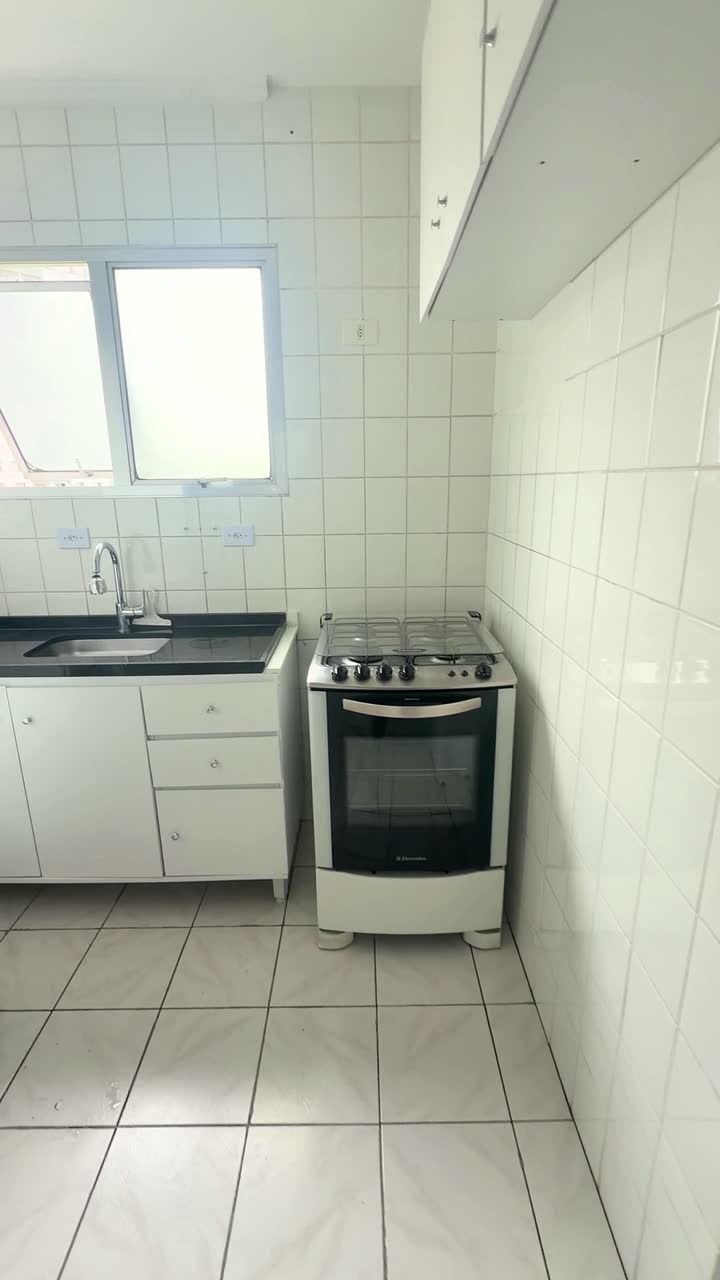 Cozinha com pia, fogão e janela