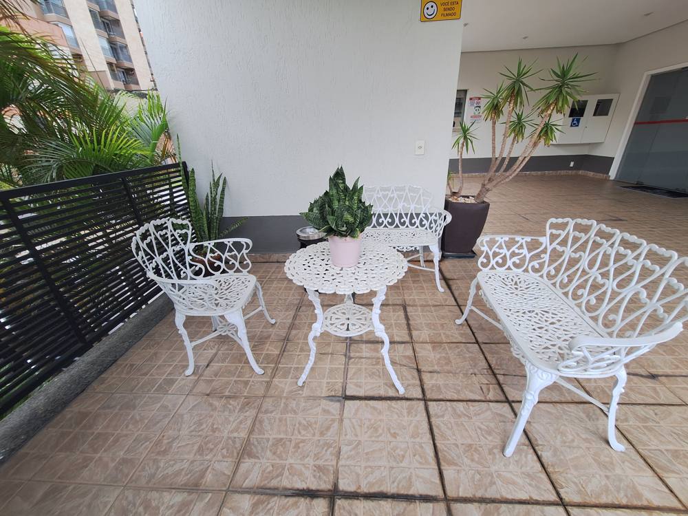 Mesa e bancos de ferro branco perto da entrada
