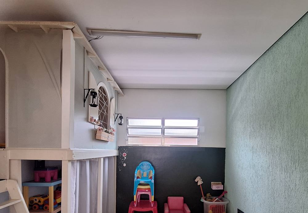 Sala infantil com casinha de madeira e cadeiras de criança